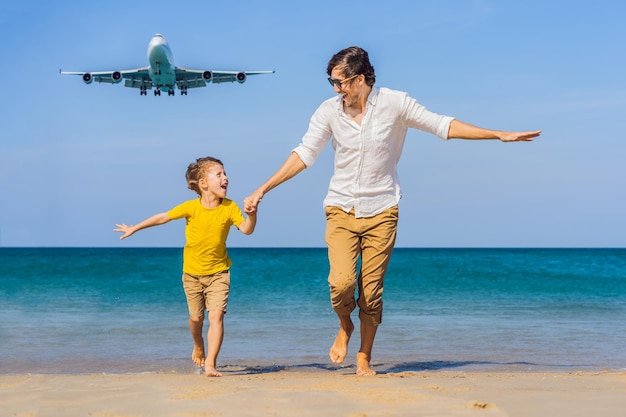 Papà e figlio si divertono sulla spiaggia a guardare gli aerei di atterraggio Viaggiare su un aereo con i bambini Concetto Spazio di testo Isola di Phuket in Thailandia Paradiso impressionante Spiaggia calda Mai Khao Paesaggio fantastico
