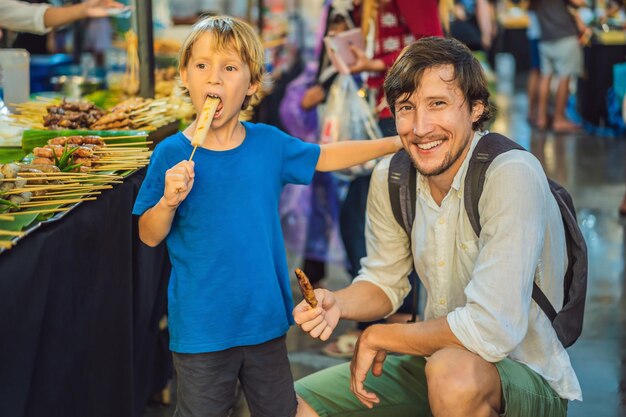 Papà e figlio sono turisti sul mercato alimentare asiatico di Walking Street