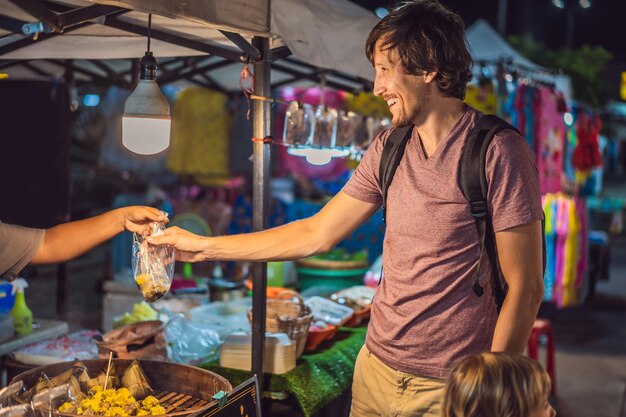 Papà e figlio sono turisti sul mercato alimentare asiatico di Walking Street