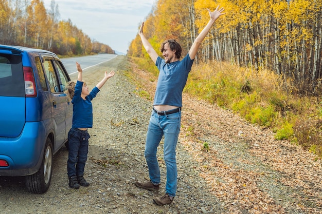 Papà e figlio stanno riposando sul lato della strada durante un viaggio su strada con il concetto di bambini