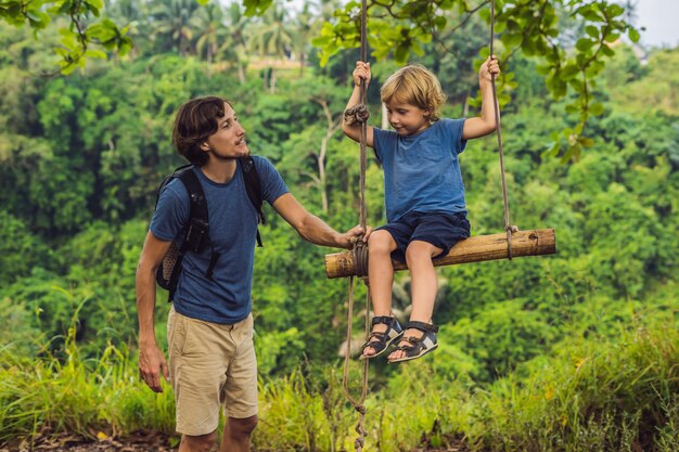 Papà e figlio sull'altalena al Campuhan Ridge Walk a Ubud, Bali