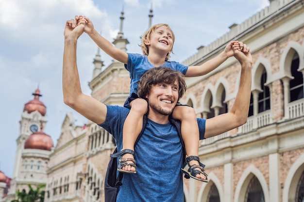 Papà e figlio sullo sfondo del Sultan Abdul Samad Building a Kuala Lumpur, in Malesia. Viaggiare con il concetto di bambini