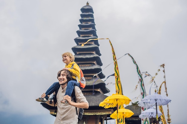 Papà e figlio sullo sfondo di Pura Ulun Danu Bratan, Bali. Tempio indù circondato da fiori sul lago Bratan, Bali. Il principale tempio dell'acqua di Shivaite a Bali, Indonesia. tempio indù. In viaggio con il bambino