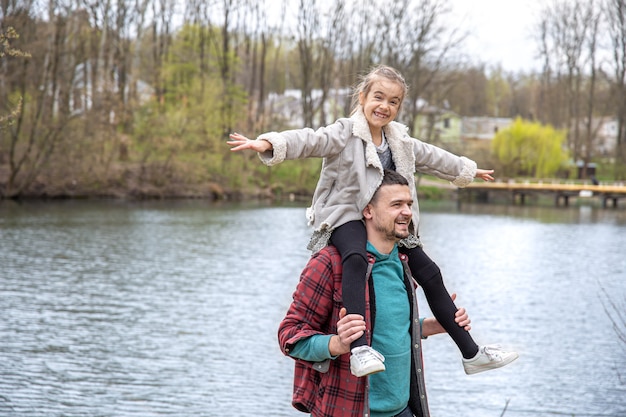 Papà e la sua piccola figlia nel bosco a fare una passeggiata lungo il fiume.