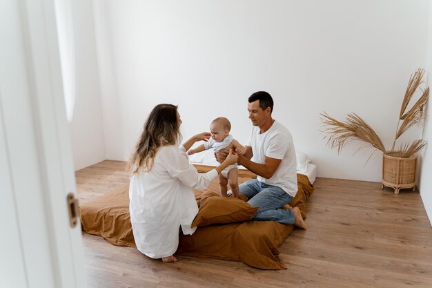 papà e mamma stanno vestendo il bambino non è felice