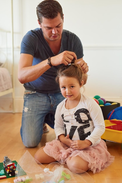 Papà fa le migliori acconciature Inquadratura di un padre che pettina i capelli delle sue figlie a casa