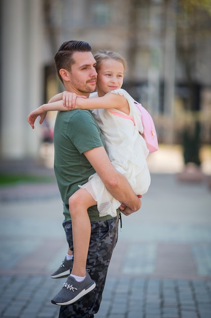 Papà felice e piccola ragazza adorabile nella città all'aperto