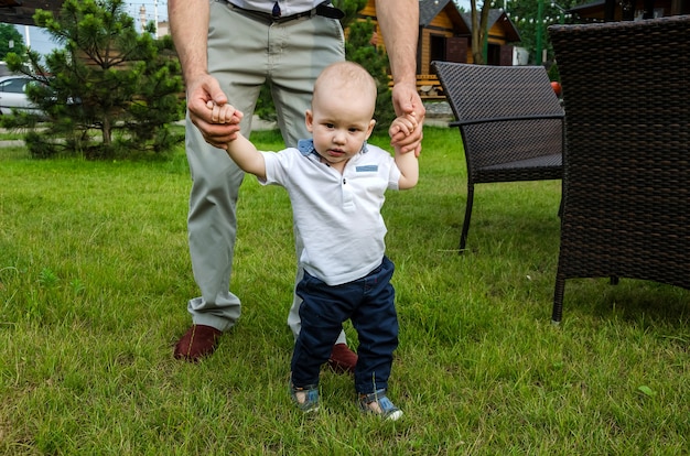 Papà guida un bambino che tiene due mani