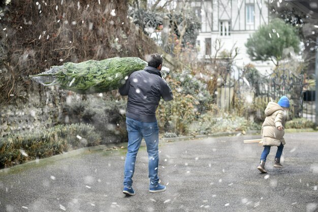 Papà ha comprato un albero di Natale e lo sta portando a casa