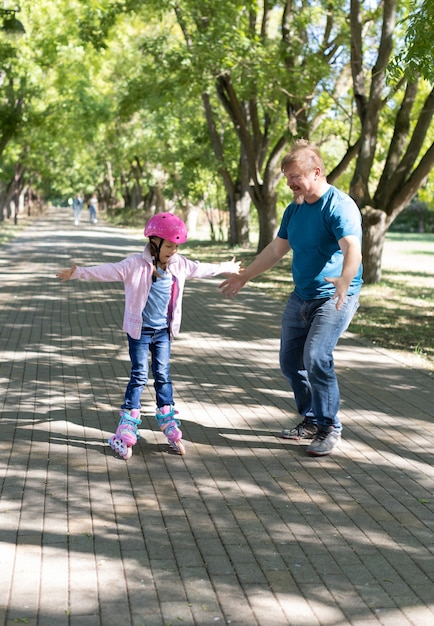 Papà insegna alla figlia a pattinare nel parco