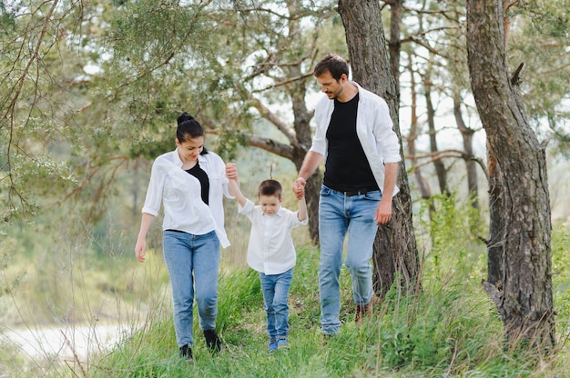 Papà, mamma e figlio piccolo si divertono insieme, all'aperto