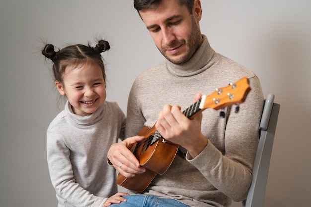 Papà suona la chitarra con sua figlia.