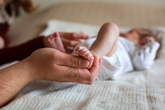 Papà tiene la gamba del bambino tra le mani