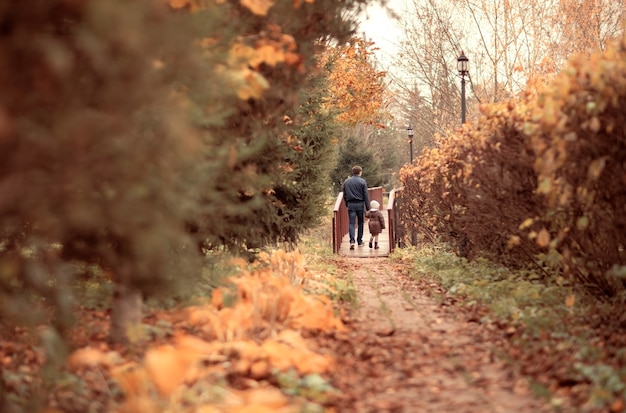 papà tiene la mano delle figlie famiglia felice che cammina in autunno parkhello settembre