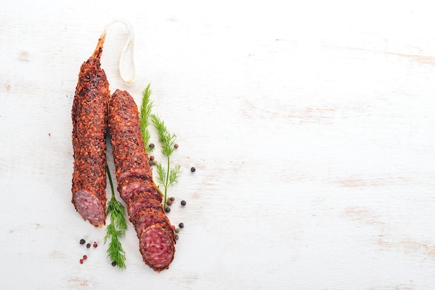 Paperoni di salsiccia Salame con paprika Su fondo di legno bianco Vista dall'alto Spazio libero per il testo