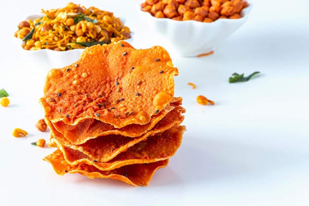 Pappad e croccante piccante dell'India meridionale mescolano Namkeen con foglie di curry di riso e arachidi e sfondo di spezie