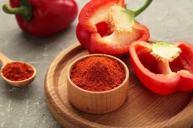 Paprika in polvere con pepe rosso fresco su sfondo grigio