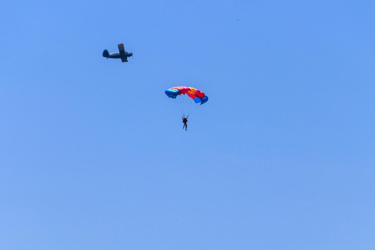 Paracadutista e aereo nel cielo blu. Stile di vita attivo. Sport estremo
