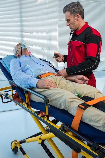 Paramedico che controlla pressione sanguigna del paziente