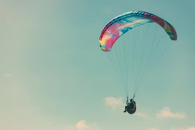 Parapendio nel cielo blu Lo sportivo che vola su un parapendio