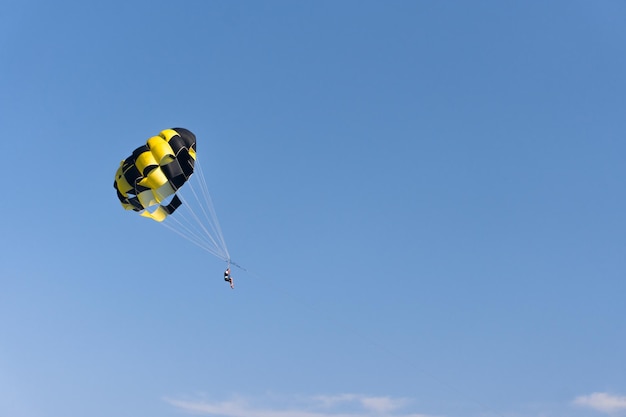 Parasailing l'uomo sta volando con un primo piano giallo del paracadute