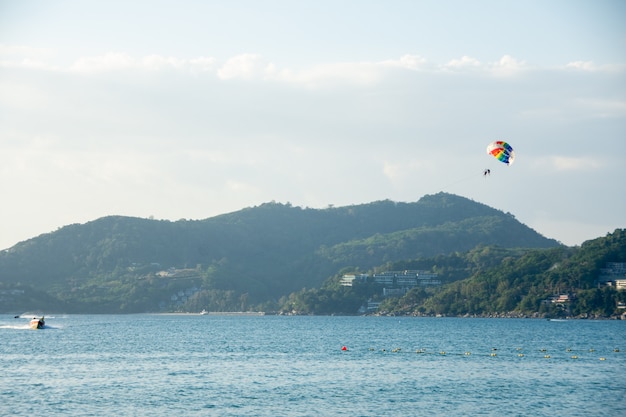 Parasailing sopra il mare con il bello fondo del cielo blu alla spiaggia di Patong,