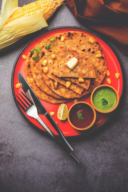 Paratha o parotha ripieni di mais dolce serviti in un piatto Ricetta di focaccia indiana preparata con il ripieno di makai