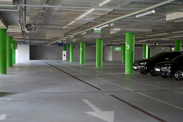 Parcheggio sotterraneo vuoto con luci a soffitto e un cartello di uscita appeso al soffitto. Parcheggio gratuito per le auto