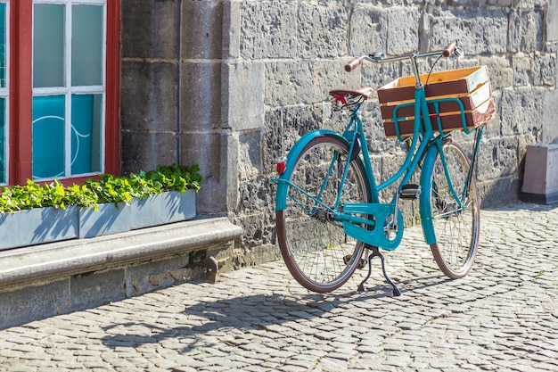 parchi per biciclette in stile retrò all&#39;esterno vicino al vecchio muro di pietra europeo e alla vetrina