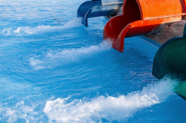 Parco acquatico con tre tubi e acqua blu in piscina. Vacanze estive