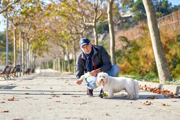 Parco della passeggiata del cane di piccola taglia dell'uomo bianco