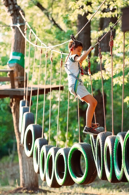 Parco delle corde. Un ragazzo supera un ostacolo su pneumatici in un parco di corde.