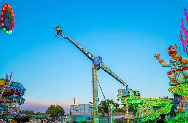 Parco divertimenti al tramonto pieno di colori e con attrazioni spinning