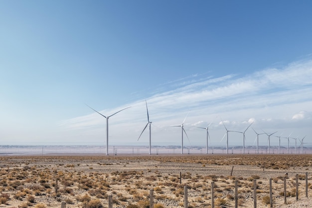 Parco eolico sul deserto nel deserto autunnale di energia pulita paesaggio contro un cielo blu