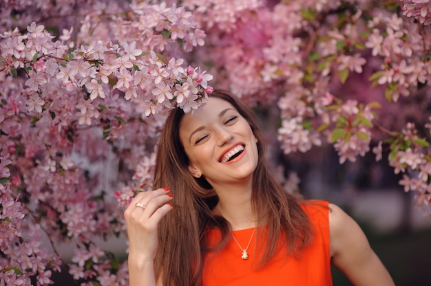 Parco fiorito della ragazza felice in primavera