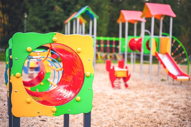 Parco giochi colorato in cortile nel parco Attività colorate di parco giochi per bambini nel parco pubblico circondato da alberi verdi