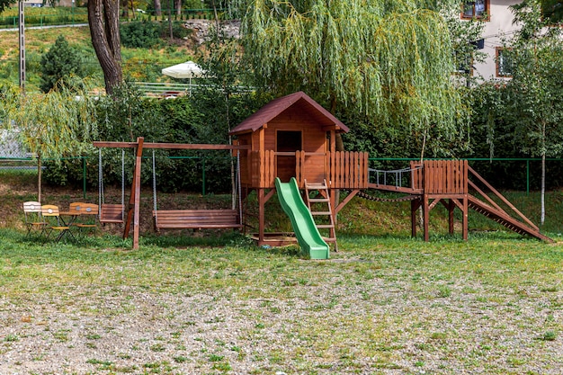 Parco giochi per bambini in legno moderno vuoto impostato sul cortile verde nel parco pubblico