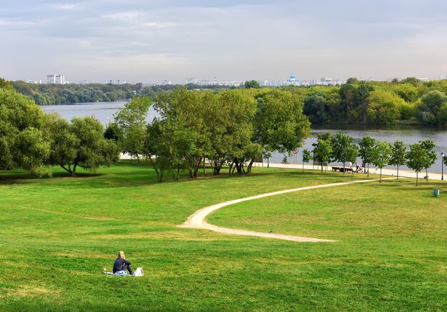 Parco Kolomenskoe in estate La ragazza nel prato su un pendio verde che scende al fiume