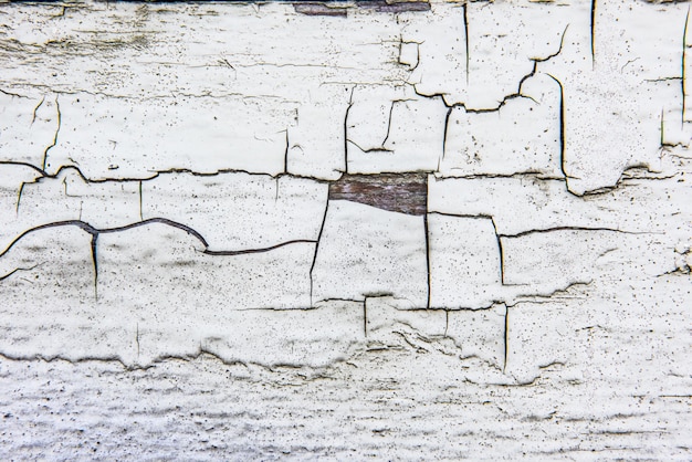 Parete di legno con vecchia vernice bianca incrinata