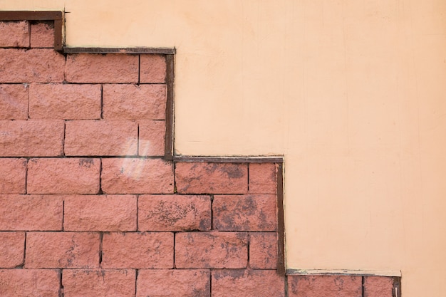 Parete dipinta per metà beige e per metà piastrellata rossa