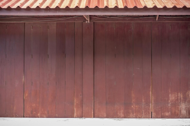 Parete e porta di legno dello sfondo classico davanti alla costruzione tradizionale d'annata della Tailandia