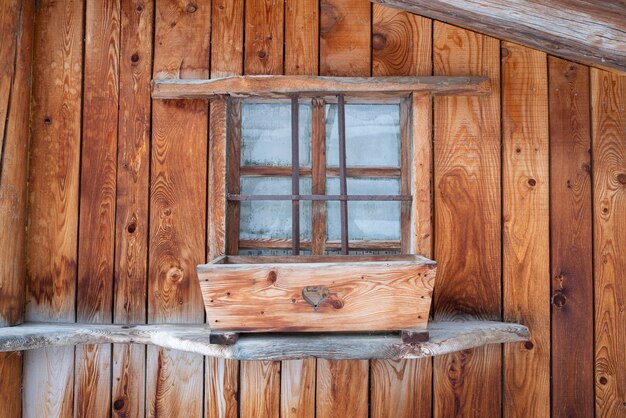 Parete in legno grezzo di chalet con finestra in montagna delle Alpi francesi