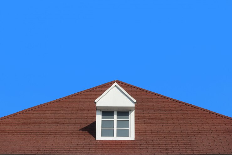 Foto parete moderna della casa di progettazione del tetto di timpano con il chiaro fondo del cielo blu.