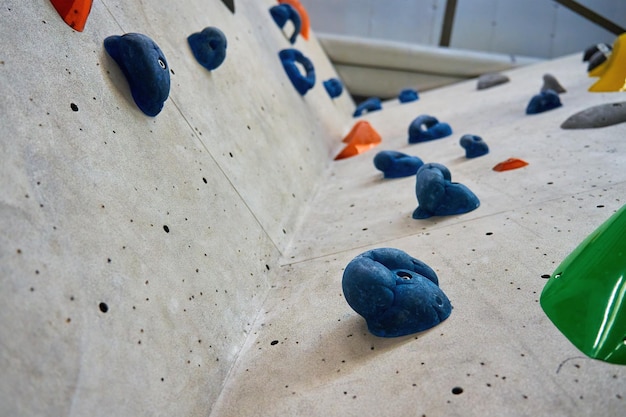 Parete per bouldering in palestra con prese per l'arrampicata concetto di sport estremo attivo