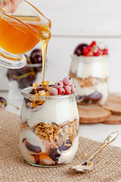 Parfait di muesli con ribes rosso, ciliegie e miele.