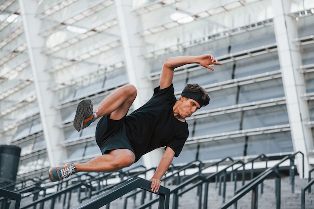 Parkour Il giovane in abiti sportivi si allena all'aperto durante il giorno