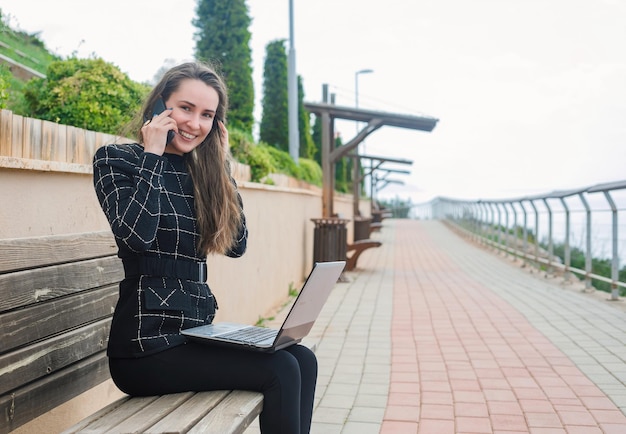 Parlando su smartphone blogger ragazza sta guardando la fotocamera nel parco