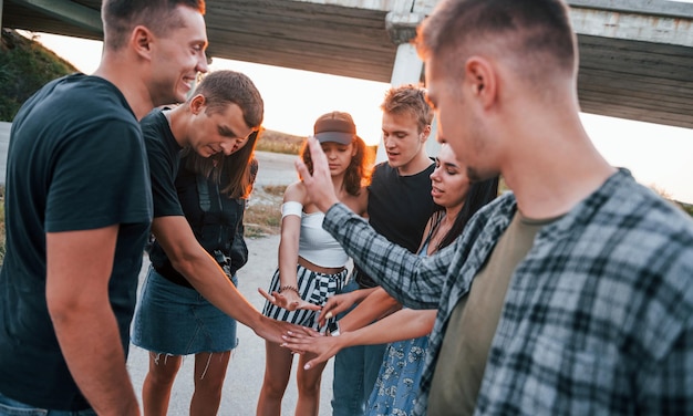 Parlare e ridere Gruppo di giovani amici allegri che si divertono insieme Festa all'aperto