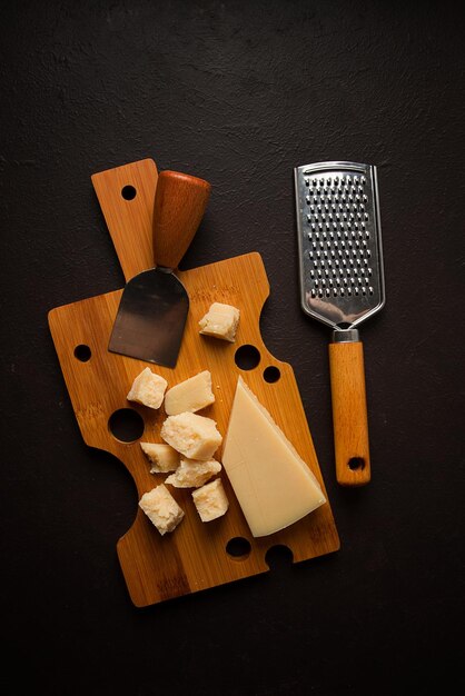 Parmigiano a pasta dura su un tagliere vista dall'alto della grattugia del coltello del formaggio nessun popolo