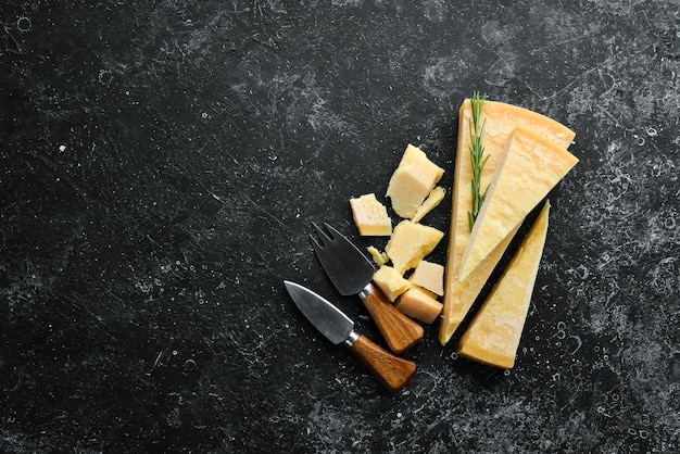 Parmigiano Pezzi di parmigiano su sfondo di pietra nera Vista dall'alto Spazio libero per il testo